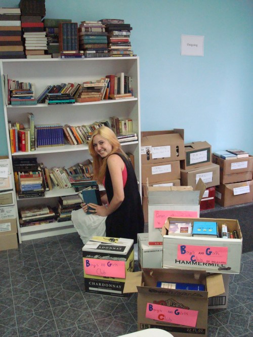 Boys and Girls Club intern Ashley McNeill selects hundreds of books which will enhance the teen center, including SAT prep, reference materials and lots of books for pleasure.