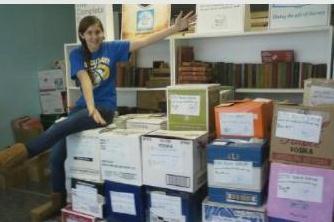 Epic Book Drive organizer Christine McNeill with some of the 60 boxes (so far!) ready to ship to New Orleans.