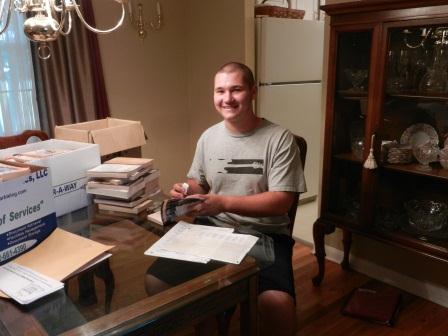 Success Won't Wait volunteer Matt McNeill, a sophomore at Archmere Academy, prepares 250 children's books for the Knollwood Community Center.