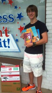 Nick Goodwin of Boyertown Area Senior High School with just a few of the 500+ books he collected for Success Won't Wait's literacy programs.