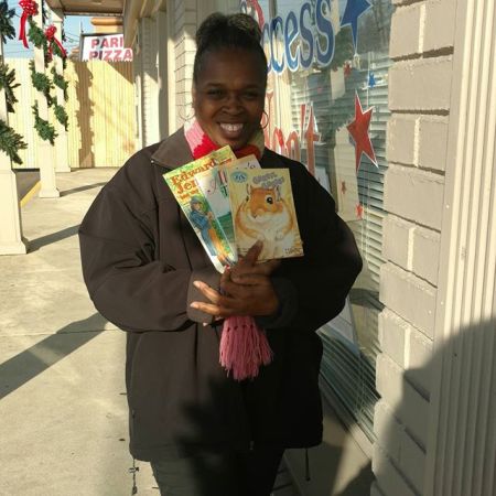 Representing Manna Academy for Learning is Ms. Parson with just a few of the over 850 children's books donated by Success Won't Wait.