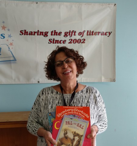Neda Green of the Friends of the Wilmington Library with just a few of the 500 books provided by Success Won't Wait.